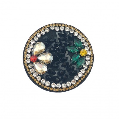 Broche redondo preto com pedras decorativas brilhantes coloridas