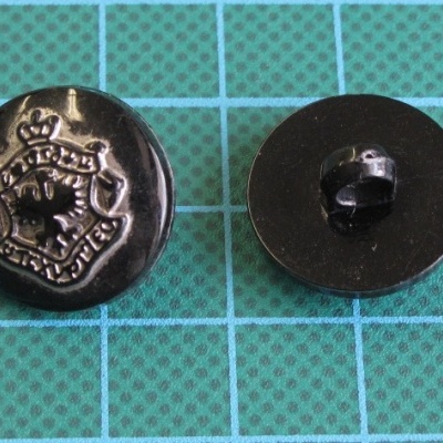 Botões pretos de metal com escudo em relevo sobre fundo azul quadriculado
