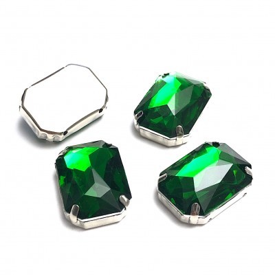 Pedras facetadas verdes com suporte metálico prateado sobre fundo branco