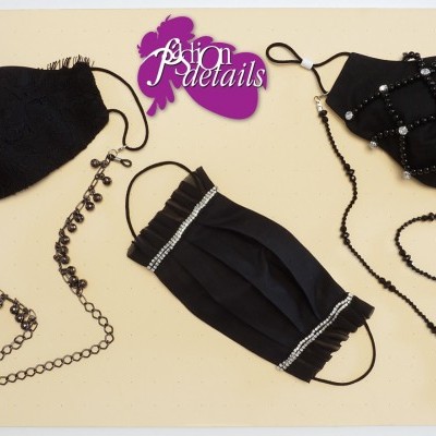 Três máscaras faciais pretas com detalhes e correntes decorativas num fundo creme com texto rosa