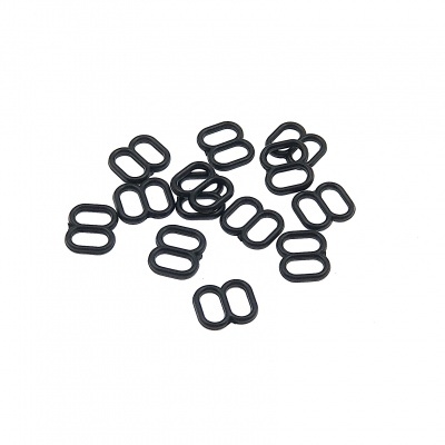 Pequenos acessórios pretos em formato de duplo anel oval sobre fundo branco