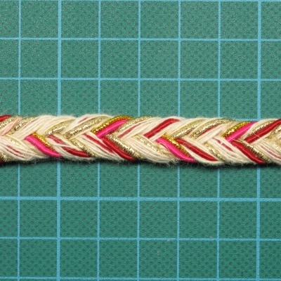 Trança decorativa colorida sobre superfície quadriculada verde