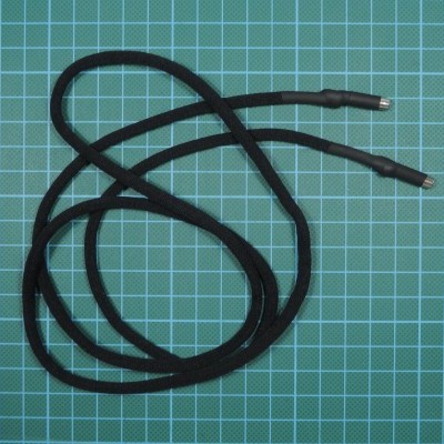 Cordão preto com pontas metálicas numa superfície de grade azul