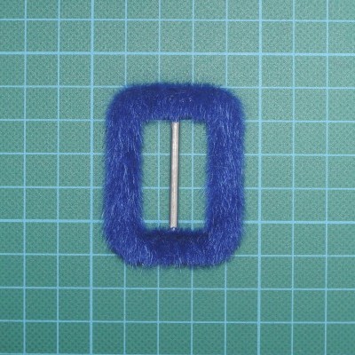 Fivela azul felpuda sobre fundo quadriculado verde.