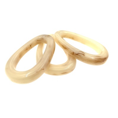 Três braceletes ovais bege translúcidos com textura lisa