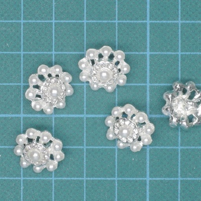 Cinco botões decorativos em forma de flor com pérolas artificiais brancas.