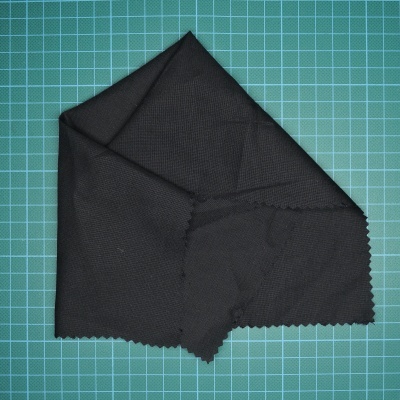 Pano de limpeza preto com textura fina sobre superfície verde quadriculada