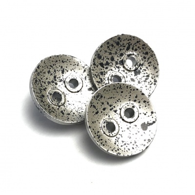Botões metálicos redondos prateados com padrão salpicado preto e dois buracos