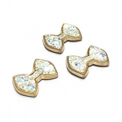 Três pequenos laços dourados com glitter branco iridescente sobre fundo branco