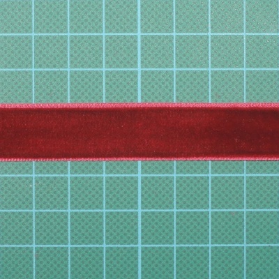 Fita de veludo vermelha sobre superfície verde quadriculada