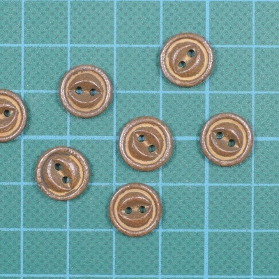 Oito botões redondos de madeira sobre base quadriculada azul claro
