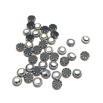 Pequenos botões metálicos redondos com topo preto texturizado e espelho