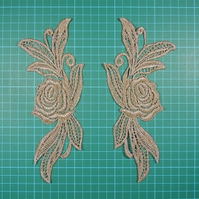 Dois apliques florais dourados sobre fundo verde com grelha quadriculada