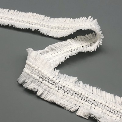 Fita decorativa branca com franjas em tecido sobre superfície cinza