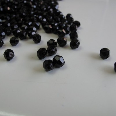Contas facetadas pretas sobre superfície branca