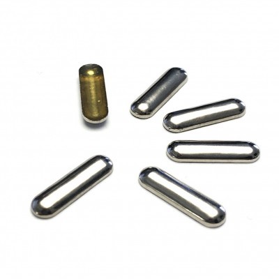 Seis cápsulas alongadas, cinco prateadas e uma dourada, sobre fundo branco.