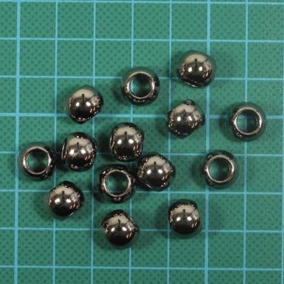 Pequenas contas metálicas brilhantes sobre superfície de grade azul