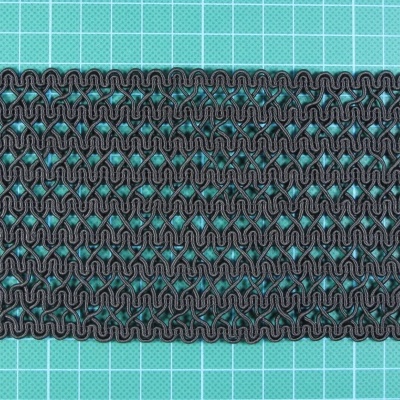 Faixa elástica preta com padrão ondulado sobre fundo azul com grelha branca