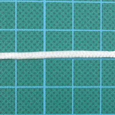 Cordão branco sobre superfície verde escura com grelha azul