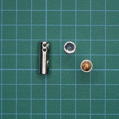 três objetos metálicos sobre fundo quadriculado verde