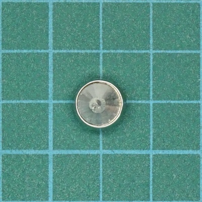 Moeda metálica redonda sobre fundo verde com linhas de grade