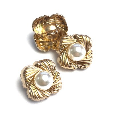 Brincos dourados com pérolas falsas sobre fundo branco