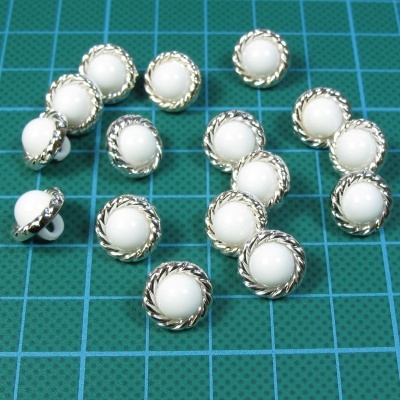 botões redondos branco e prata sobre grade verde