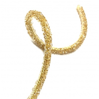 Fio de contas douradas brilhantes com textura facetada sobre fundo branco