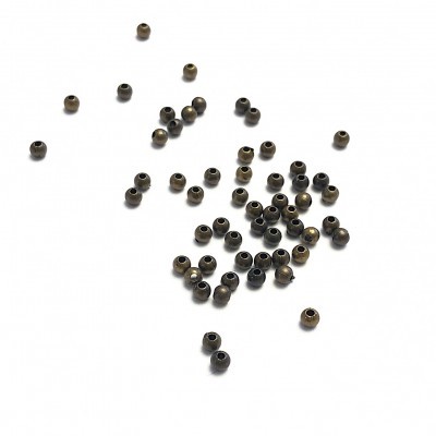 Pequenas contas metálicas esféricas cor bronze sobre fundo branco