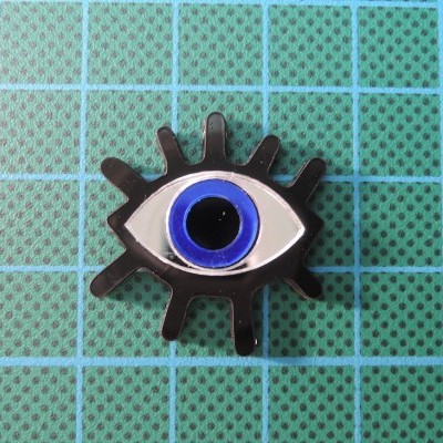 Objeto decorativo em forma de olho estilizado com pestanas