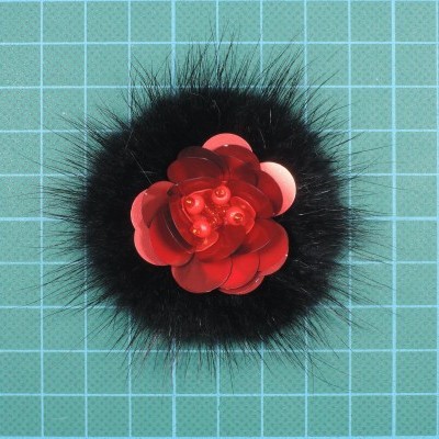 Acessório decorativo com pele preta e flor vermelha sobre superfície azul quadriculada