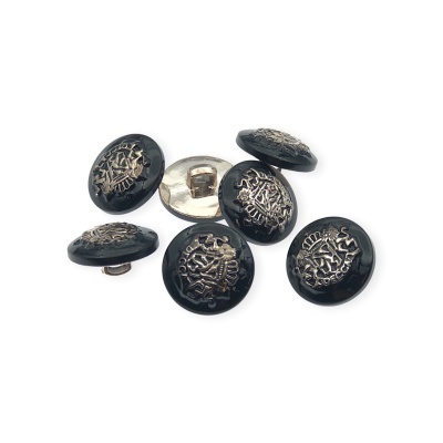 Conjunto de seis botões redondos pretos com desenhos prateados em relevo e um botão virado mostrando a parte traseira prateada.