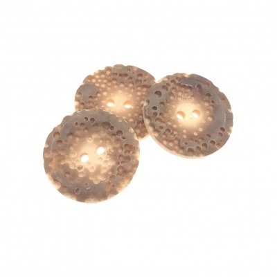 Três botões redondos bege com padrão perfurado em fundo branco