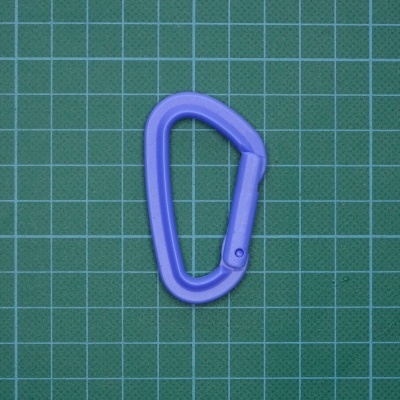 Mosquetão de plástico roxo sobre fundo verde quadriculado