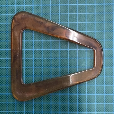 Clip triangular castanho transparente sobre fundo azul quadriculado