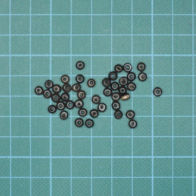 Vários rolamentos pequenos metálicos sobre superfície azul quadriculada