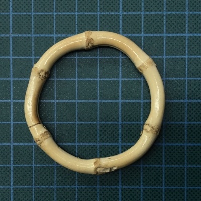 Anel redondo de bambu claro sobre superfície quadriculada azul escuro