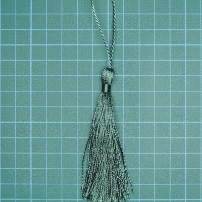 Pendente tassel cinza com fio torcido em fundo de grade azul clara