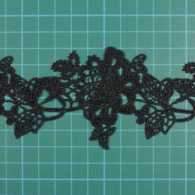 Renda preta floral sobre superfície quadriculada verde