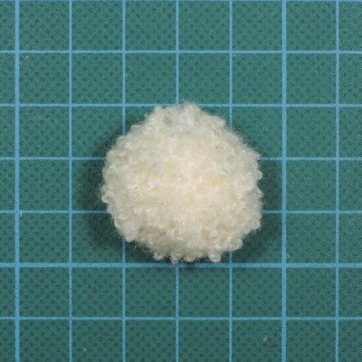 Bola esponjosa branca sobre fundo verde com grelha azul