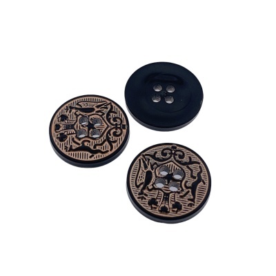 Três botões decorativos, dois com padrão preto sobre castanho e um preto liso.