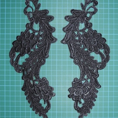 Par de apliques de renda preta com padrão floral e folhas em fundo verde quadriculado