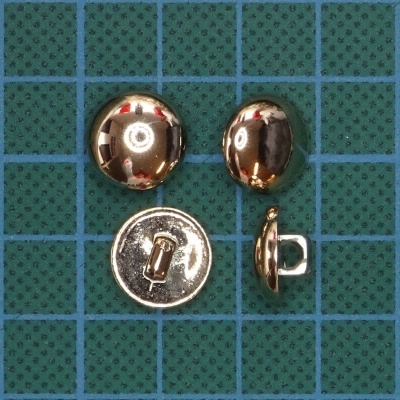 Botões metálicos dourados sobre superfície verde quadriculada