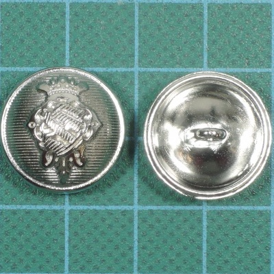 Dois botões metálicos prateados sobre superfície quadriculada verde