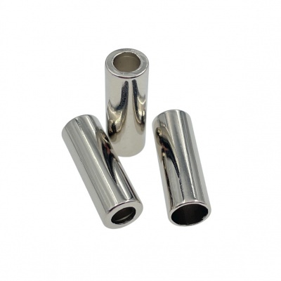 Três cilindros metálicos prateados com orifício central