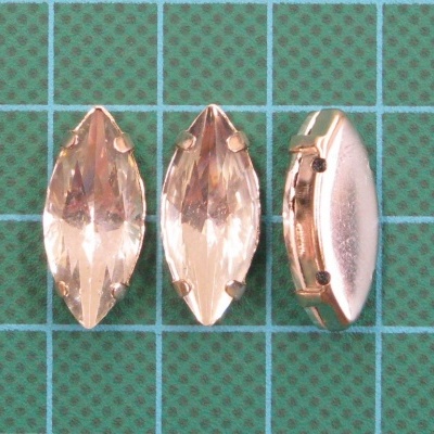 Pedras de cristal cor de champanhe com engaste dourado sobre base quadriculada