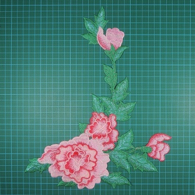 Aplicação em tecido com flores cor-de-rosa e folhas verdes bordadas