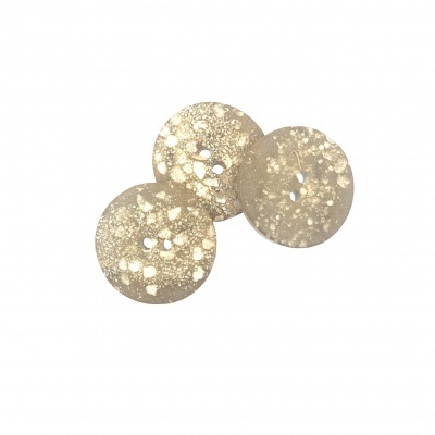 Três botões redondos bege com manchas claras e quatro furos cada