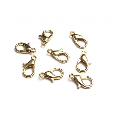 Sete fechos de lagosta dourados para bijuteria em fundo branco