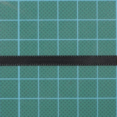 Fita preta fina sobre superfície verde quadriculada